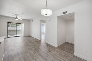 the living room and dining room in a new home with white walls and wood floors